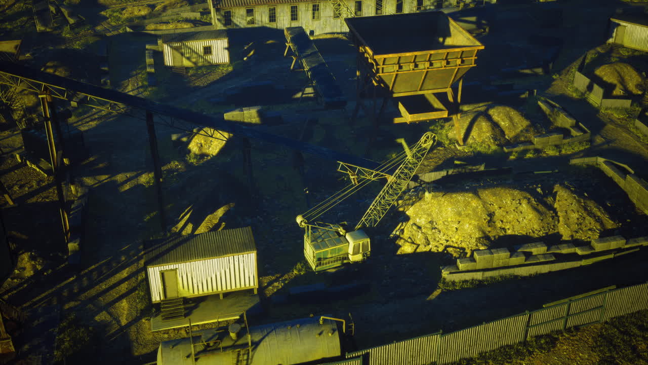 Mining site with machinery and stockpiles during early morning light