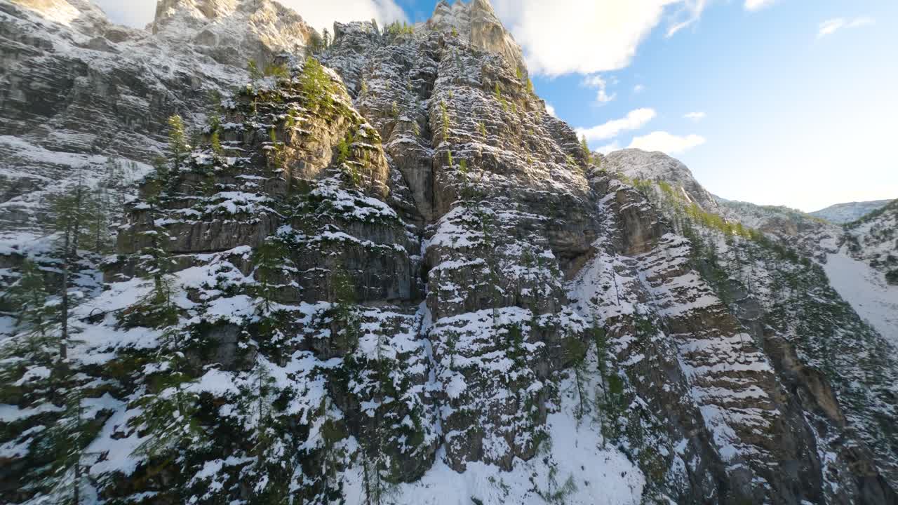FPV drone flight up a steep mountain covered by snow in Triglav National Park in Slovenia