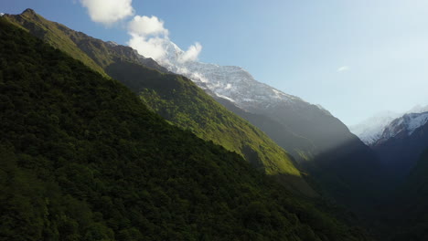 Epic-aerial-drone-shot-of-the-sun-shining-on-the-face-of-the-Annapurna-mountains,-Nepal