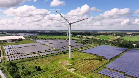 una turbina eólica en un campo solar, generando energía renovable - nubes ligeras, cielo azul, campos verdes, planta de energía fotovoltaica