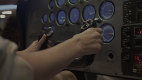 Close-of-hands-in-the-stick-of-a-flight-simulator-cockpit