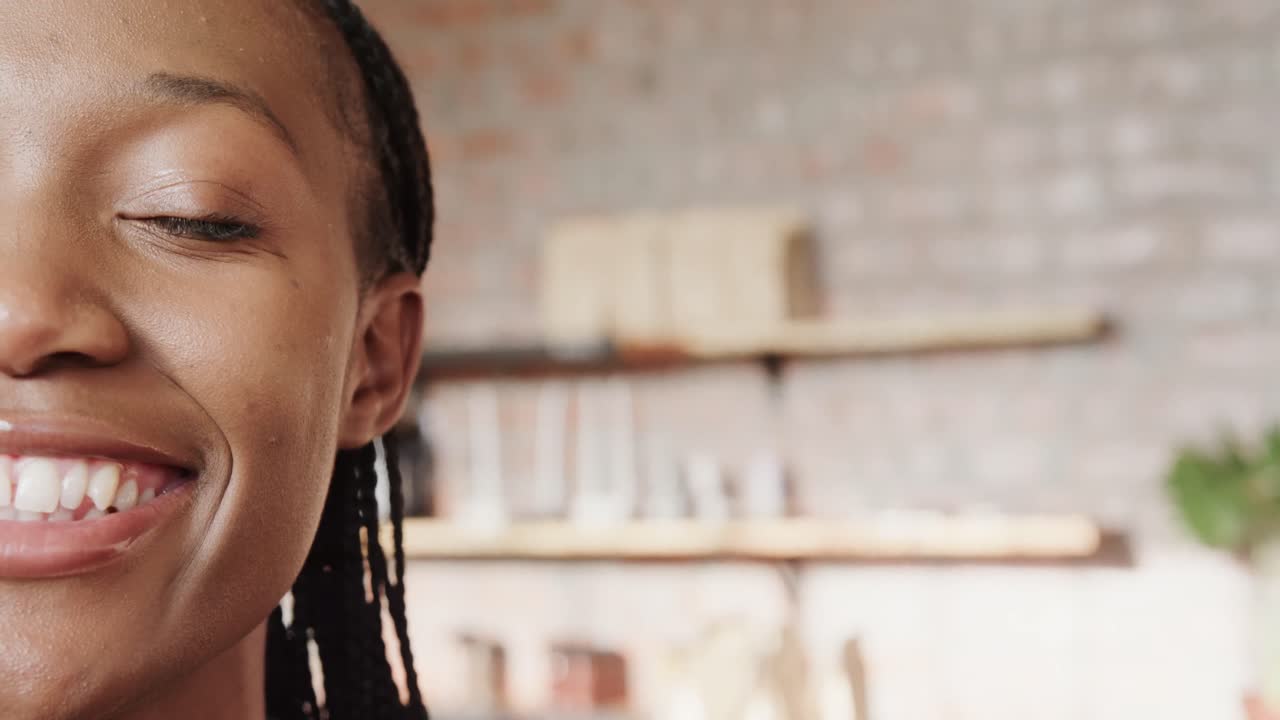 Mezzo ritratto di felice donna afroamericana che sorride in caffetteria, spazio per il testo, slow motion