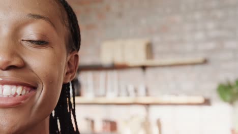 Half-portrait-of-happy-african-american-woman-smiling-at-coffee-shop,-copy-space,-slow-motion