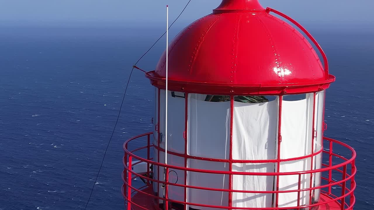 Exploring the red lighthouse overlooking the ocean in Madeira, Portugal