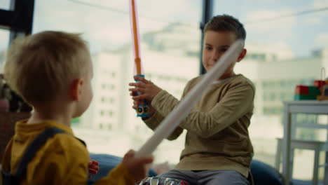 siblings crossing toy swords at home. beautiful children enjoying time together.