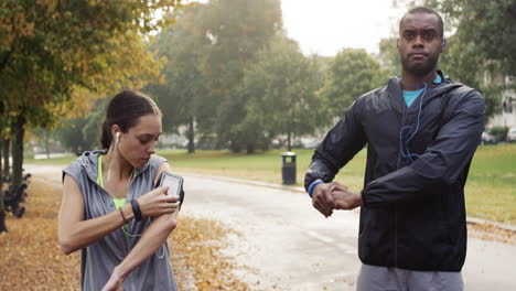 athletic couple running in park wearing wearable technology connected devices