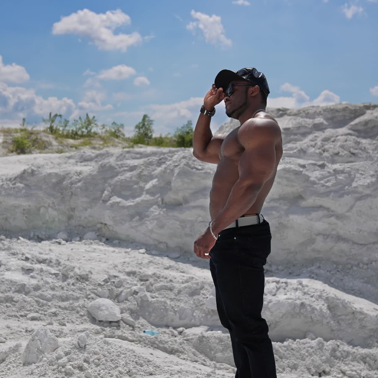 Fit worked-out man walking out with blue sky. Full length view of the handsome muscular strong man with naked torso posing outdoor