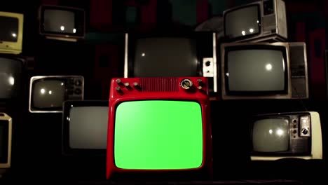 old red television set with green screen among many vintage televisions. 4k.