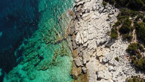 stony shoreline on the secluded bay at emplisi beach revealed fiskardo town in kefalonia, ionian islands, greece