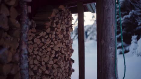 Holzstapel-Mit-Einem-Mann,-Der-Etwas-Holt-Und-Es-Auf-Einen-Holzkorb-Aus-Metall-Legt