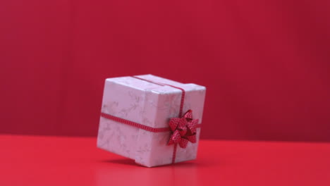 christmas gift dropping and bouncing on red background