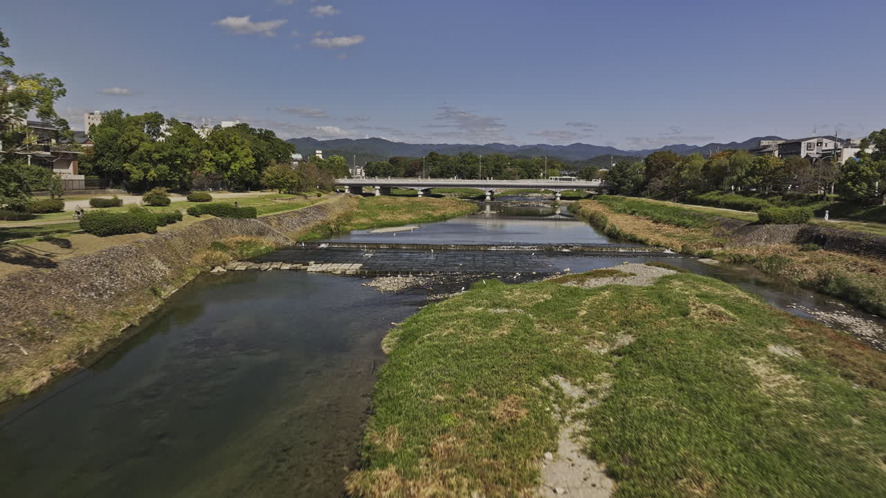 Kyoto Japan Aerial v57 low flyover Kamo river towards Kamogawa Delta capturing river crossing bridges, riverside parks in Sakyo ward and mountain views - Shot with Mavic 3 Pro Cine - Oct 8th 2023