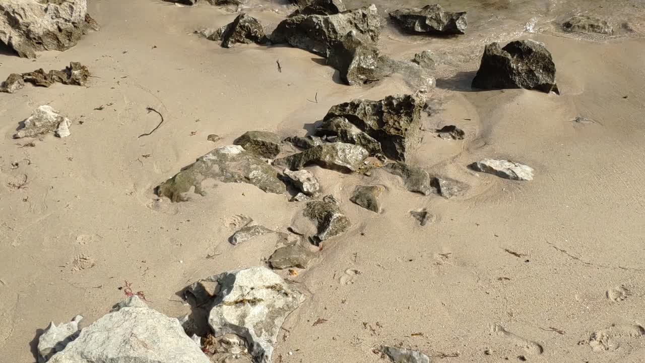 Rocky sand at low tide, Gulpiyuri beach in Asturias under bright morning sun
