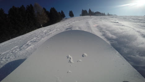 a closeup of a snowboard nose sliding on the snow