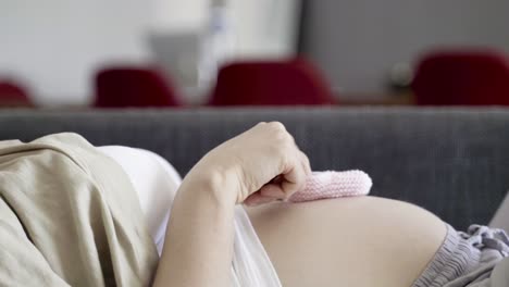 side view of pregnant woman playing with babys booties