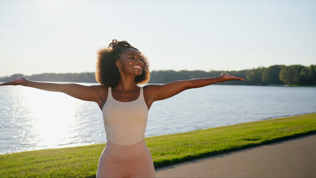 Happy Young Woman Spreading Arms by Lake on Sunny Day