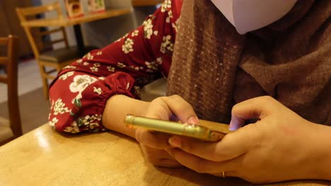 mujer usando un teléfono inteligente en un restaurante