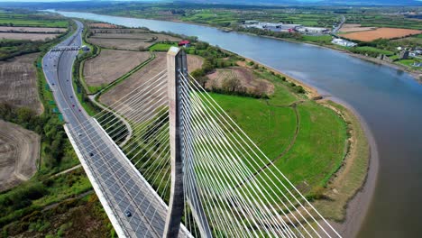 Drone-distinctive-cable-stay-bridge-with-river-and-toll-plaza-on-dual-carriageway-Thomas-Francis-Meagher-Bridge-in-Waterford-Ireland-establishing-shot-of-iconic-structure