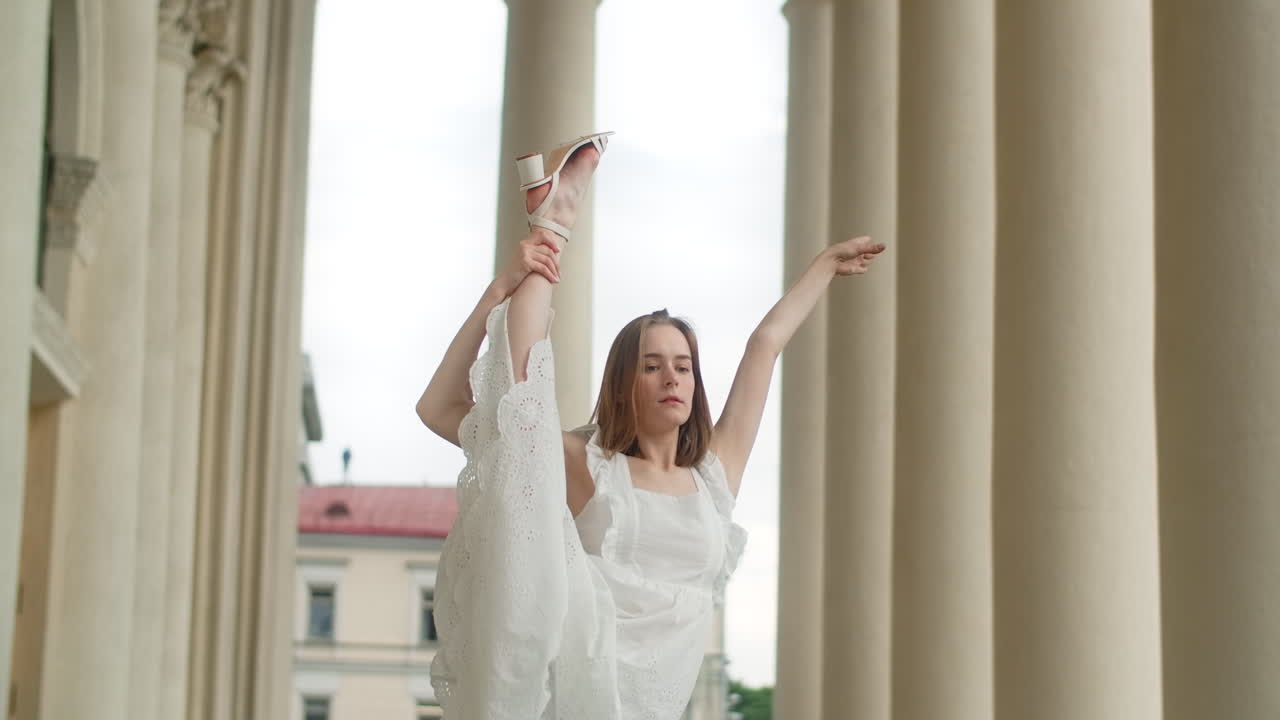 Woman in white dress stretching outdoors