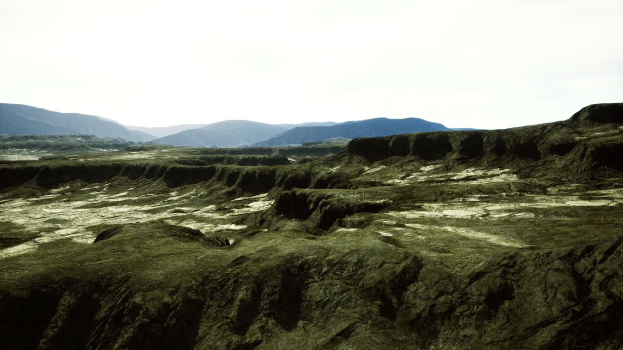Vast rocky terrain characterized by rugged hills and distant mountains
