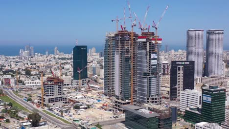 aerial view of a bustling city skyline with skyscrapers under construction and numerous cranes