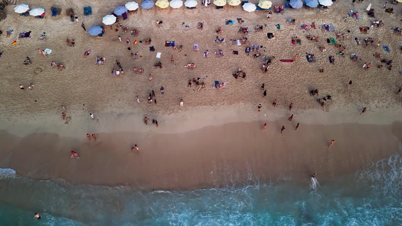 Beautiful overhead drone footage of Dreamland Beach with turquoise ocean meeting smooth golden sand, calm waves, and a peaceful holiday vibe surrounded by Bali’s natural tropical charm