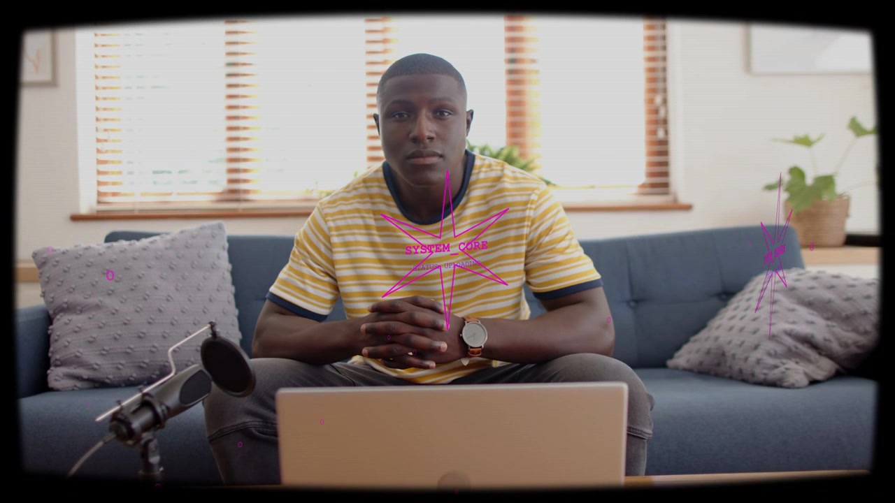 Camera starting, host seated, adjusting, pink overlays crossing laptop and mic, preparing stream