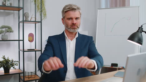 businessman working on laptop showing stop gestuge, danger, rejection, warning, crisis, prohibition