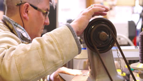 bespoke shoemaker stitching together leather pieces for shoe