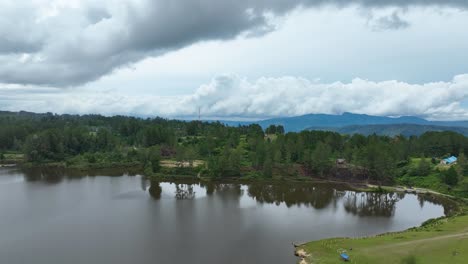 Toma-Aérea-Del-Sereno-Lago-Aeknetonang-De-Guisantes,-Isla-Samosir-Dentro-Del-Lago-Toba,-Cielo-Nublado