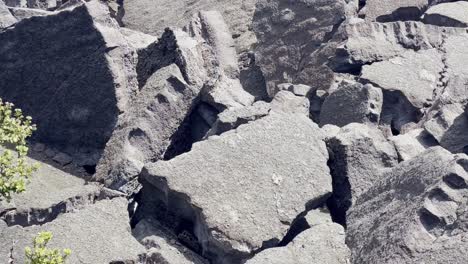 Cinematic close-up panning shot of mounds of dried lava rock along the Kilauea Iki trail in Hawai&#039;i Volcanoes National Park