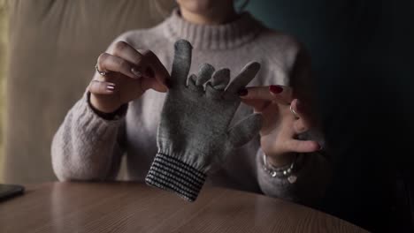 gray winter gloves on the table