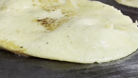cooking a tortilla on a hot pan