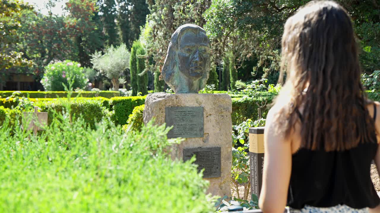 красивая женщина смотрит на настоящую статую картуха де вальдемосса