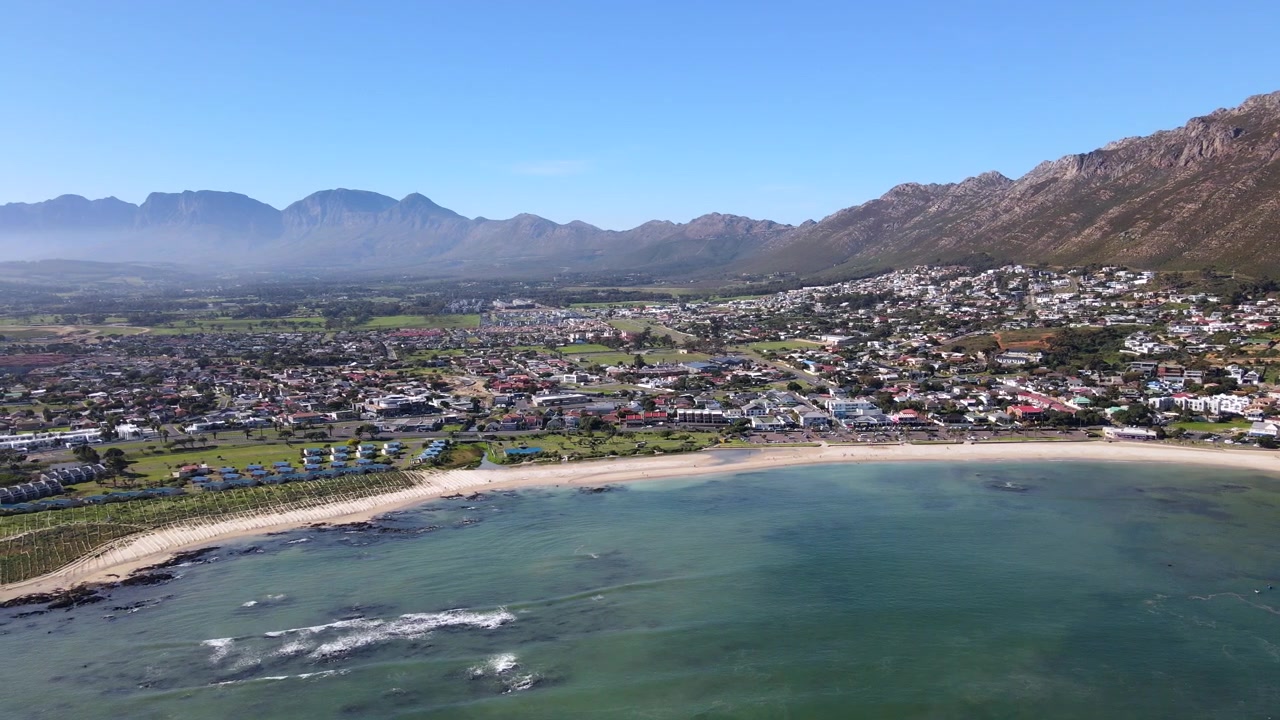 Vista aérea desde el océano de la playa principal de Gordon's Bay y la cuenca de Helderberg