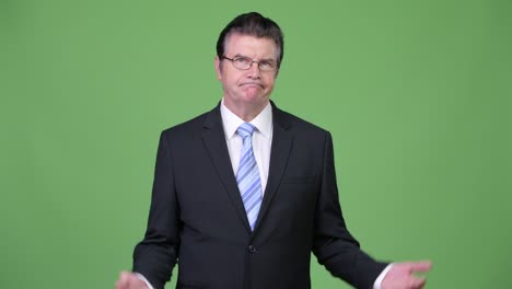 Senior handsome businessman looking bored