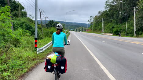 women in the sunny day cycling in the road of nan province, thailand