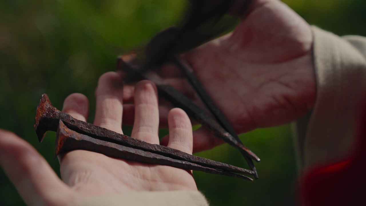 Closeup Jesus Christ hands trembling while gripping then opening to show iron nails