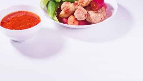 albóndigas fritas y salsa para mojar en un fondo blanco