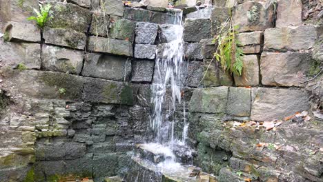 Cascada-Otoñal-Húmeda-Que-Fluye-Naturalmente-Sobre-Bloques-De-Piedra-Cortada