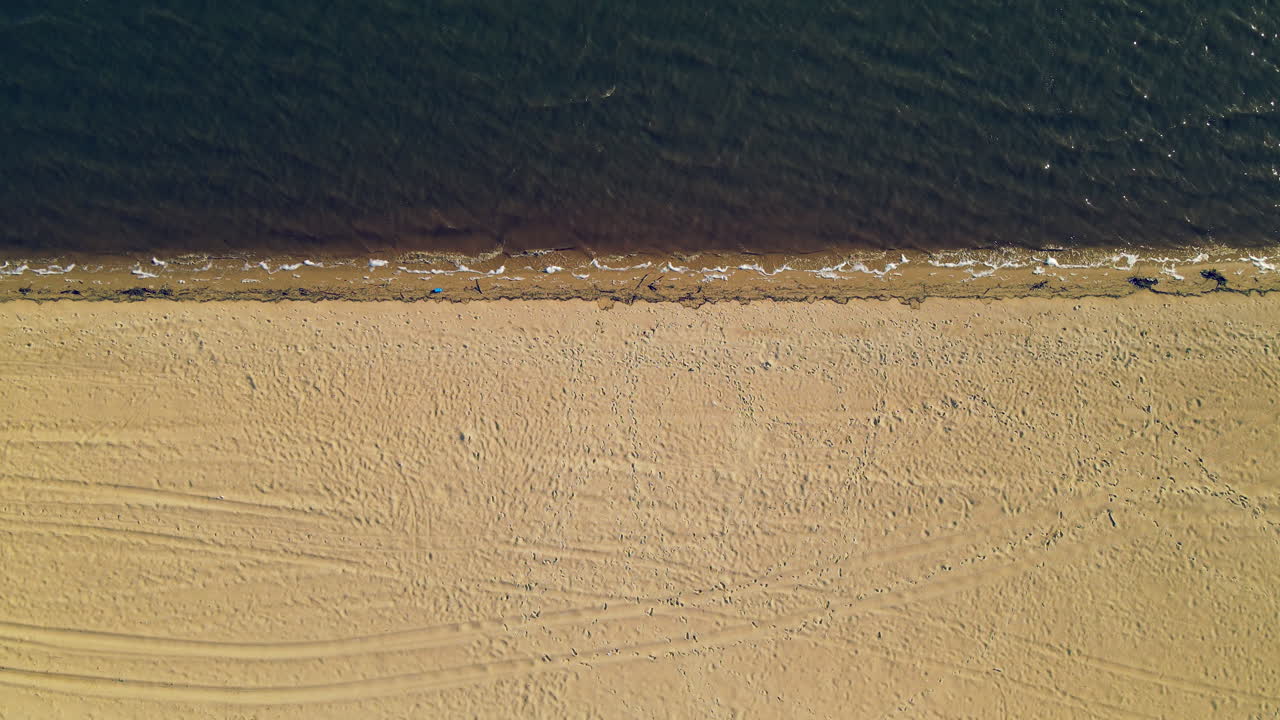 Top-ned luftfoto af tom sandstrand og rolig atlanterhavskyst på en solskinsdag i Spanien, Europa