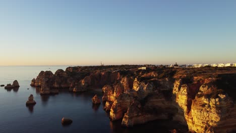 Slow-aerial-jib-up-revealing-a-quiet-cliff-side-during-golden-hour