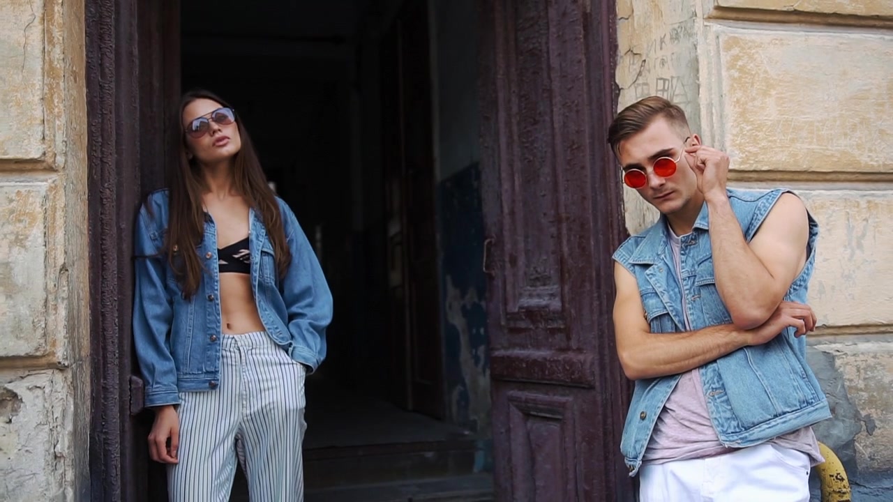 Giovane coppia elegante in posa con abiti in denim all'aperto