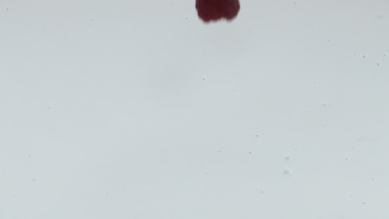 Ripe raspberry falling yogurt in super slow motion close up. Homemade dessert.