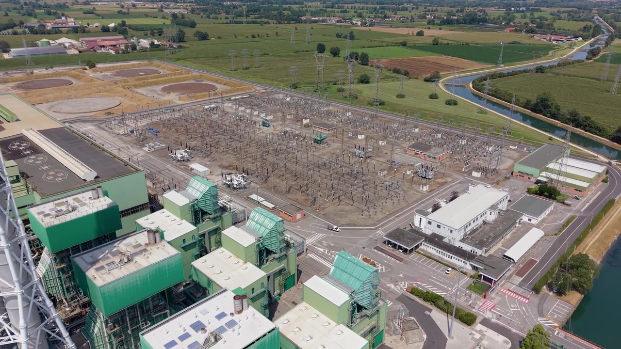 Riprese aeree di un importante impianto di generazione di energia nel Nord Italia, che mostrano grandi strutture industriali e infrastrutture energetiche nel paesaggio lombardo