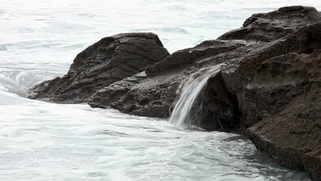 Cascadas-En-Miniatura-Creadas-Sobre-Piscinas-De-Roca-Junto-Al-Mar-Cuando-Son-Aplastadas-Por-Las-Olas