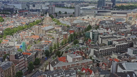 amsterdam netherlands aerial v8 birds eye view overlooking residential buildings along nieuwezijds voorburgwal street, tilt up reveals major railway train station and neighborhoods - august 2021