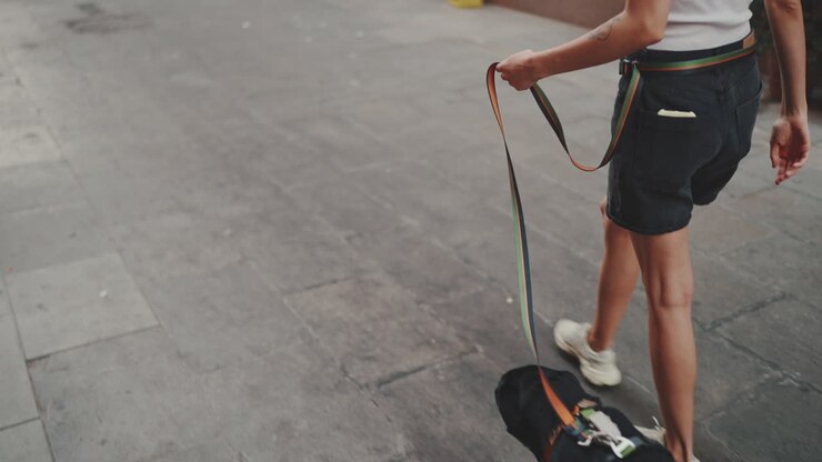 Woman walking a black dog on a leash