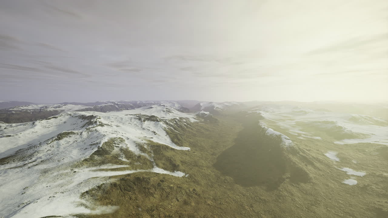 Expansive view of snow capped mountains under a soft golden light