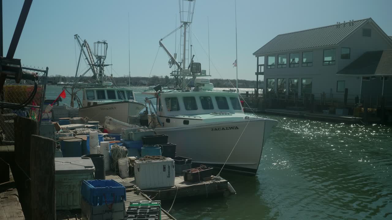 A quiet marina view with fishing boats docked along the waterfront bobbing slowly as water glistens